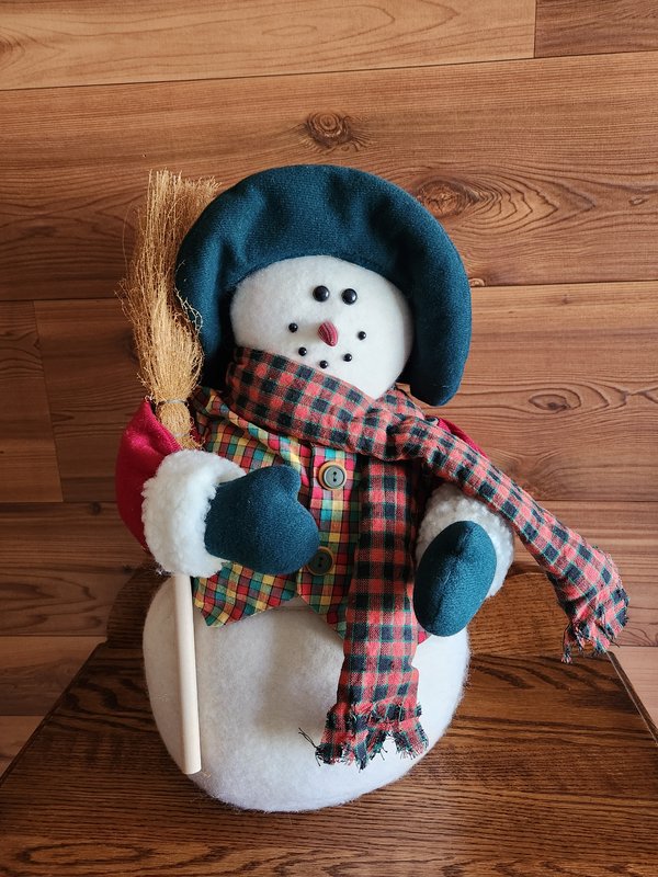 Snowman holding straw broom