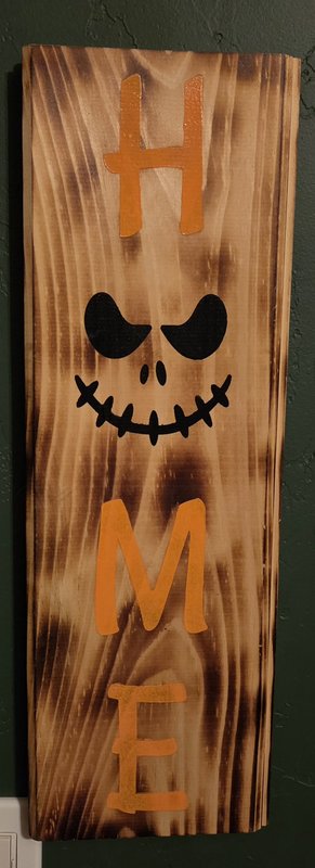 Wood-burned H-O-M-E plaque with skull face